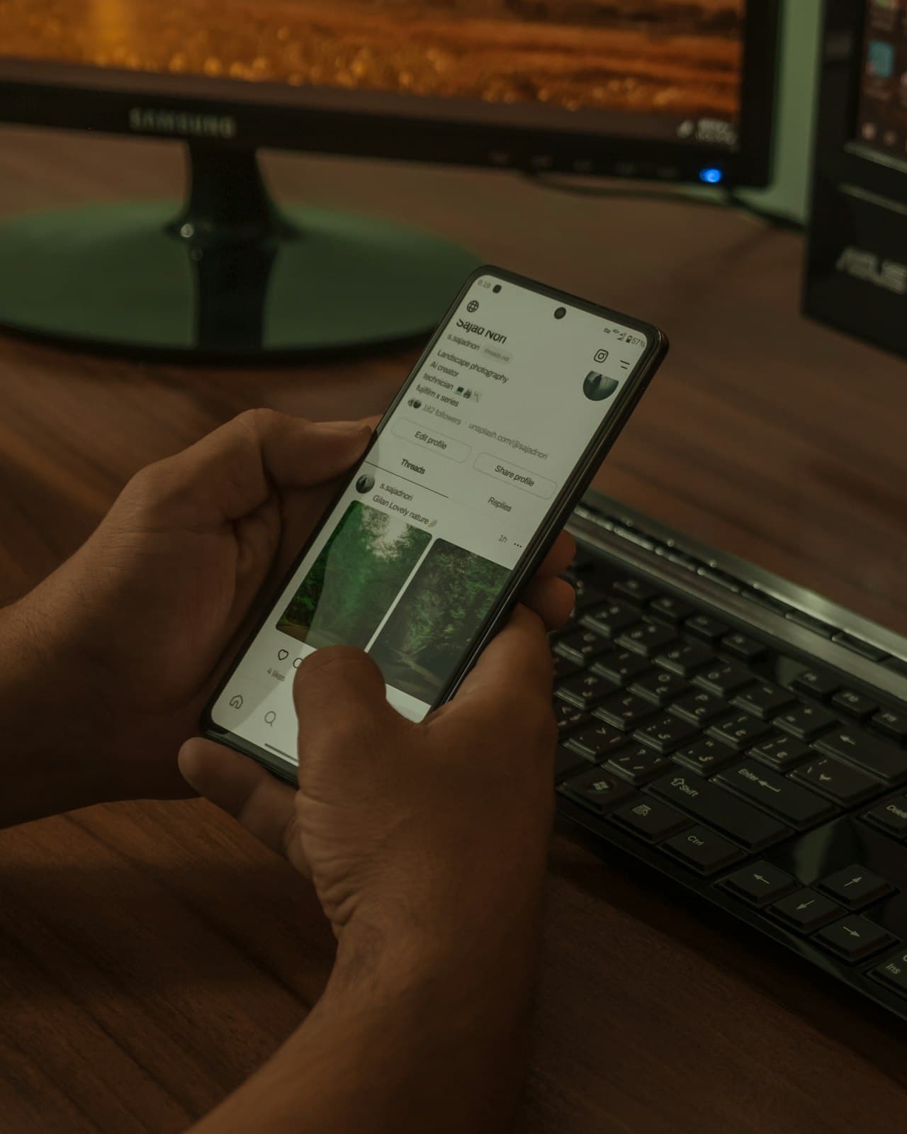 Personne au téléphone devant son ordinateur de bureau