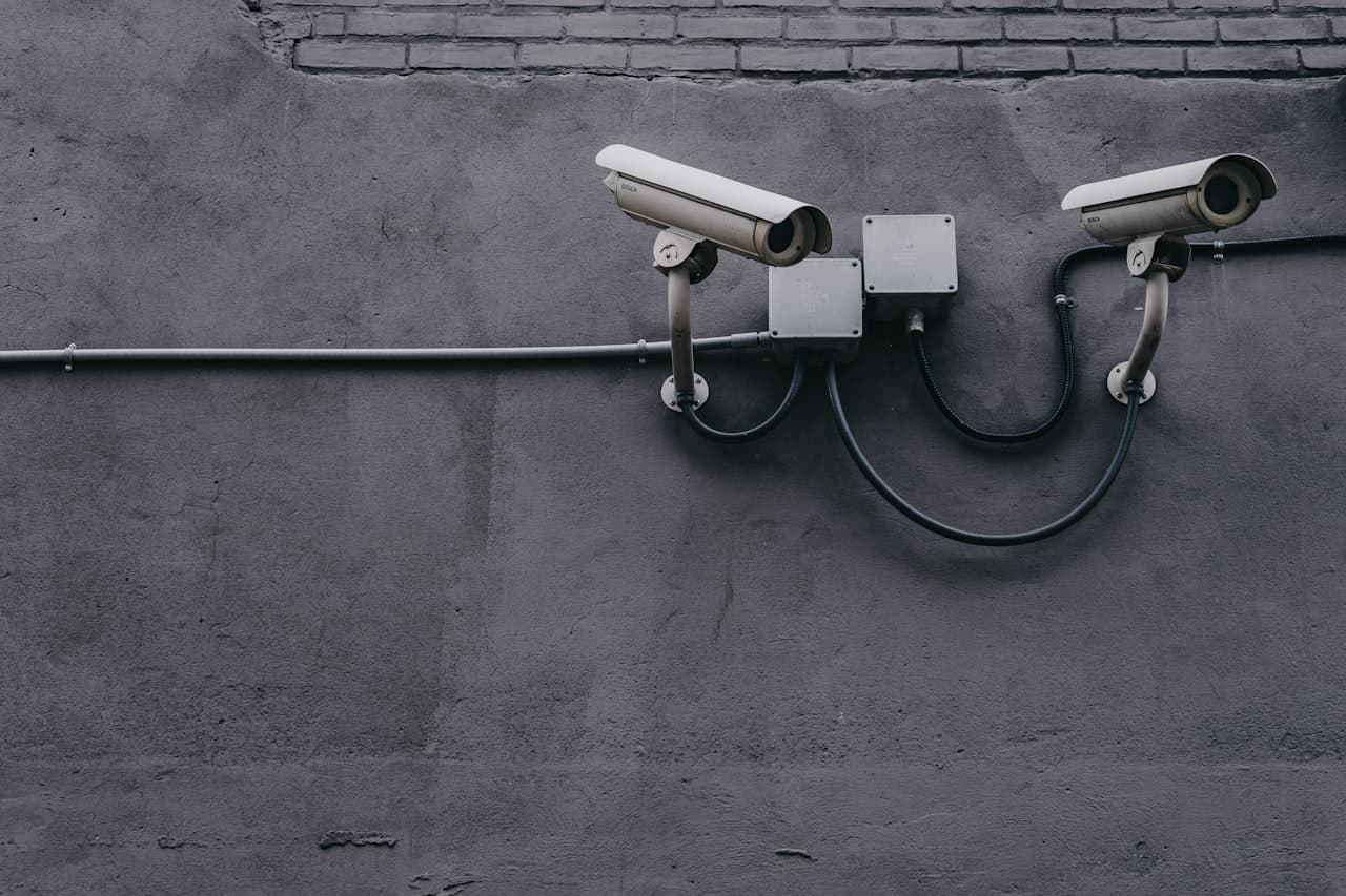 Deux caméras de surveillance fixées sur un mur en béton