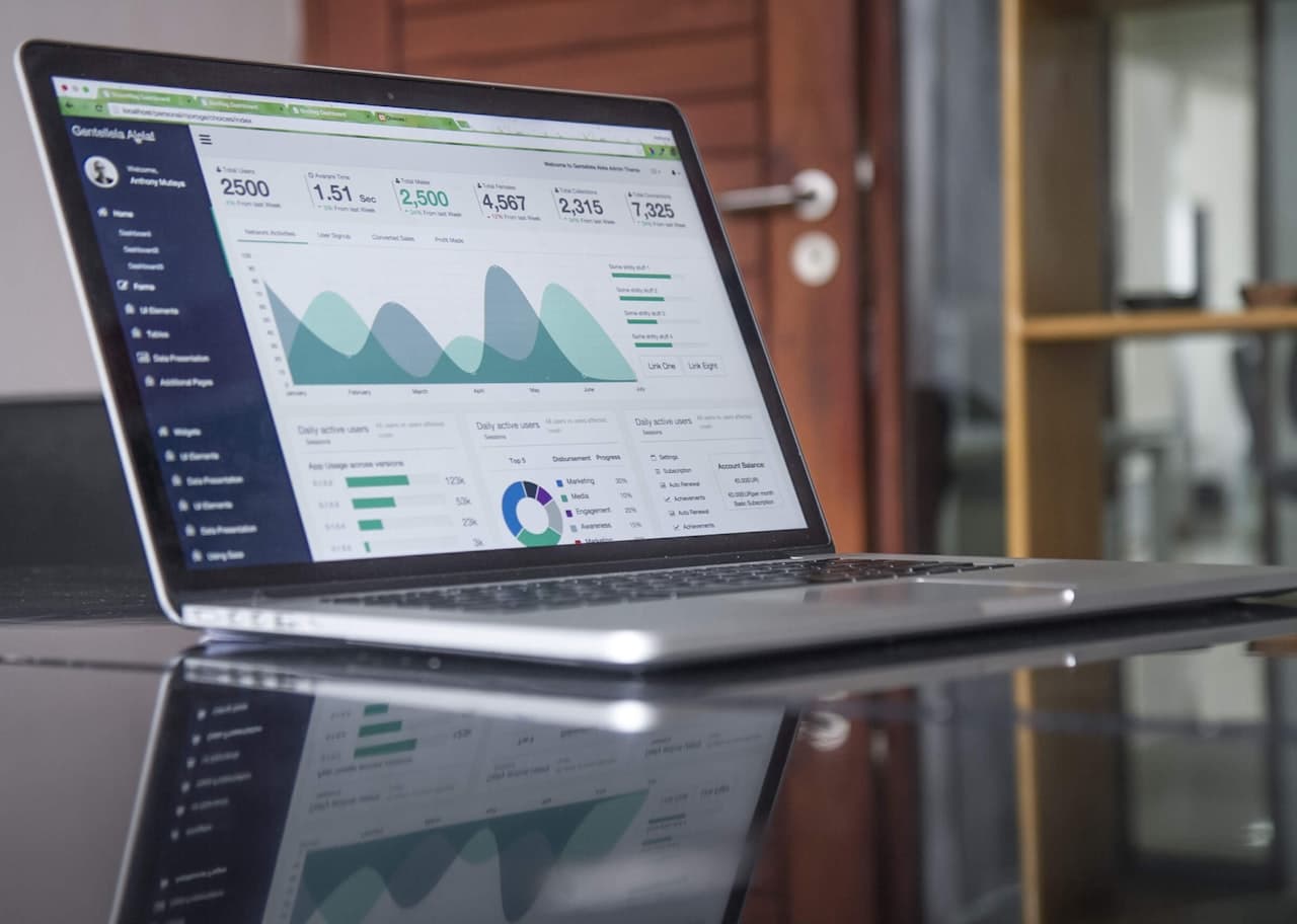 Ordinateur portable affichant des graphiques d'analyse sur bureau en verre