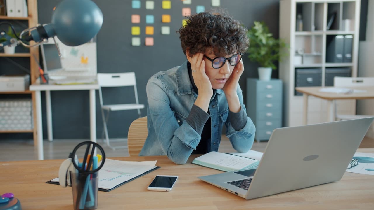 Professionnelle stressée devant son ordinateur au bureau