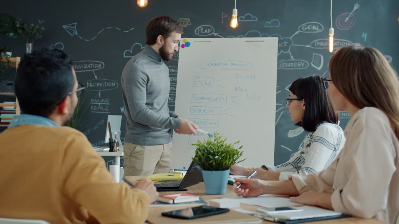 Équipe IT planifiant une stratégie sur tableau blanc