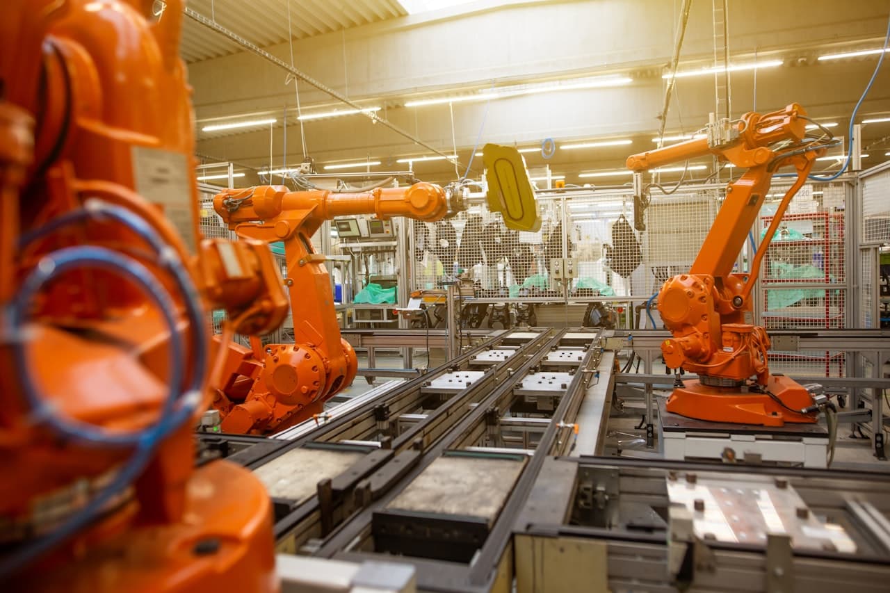 Robots industriels orange en action dans une usine automatisée