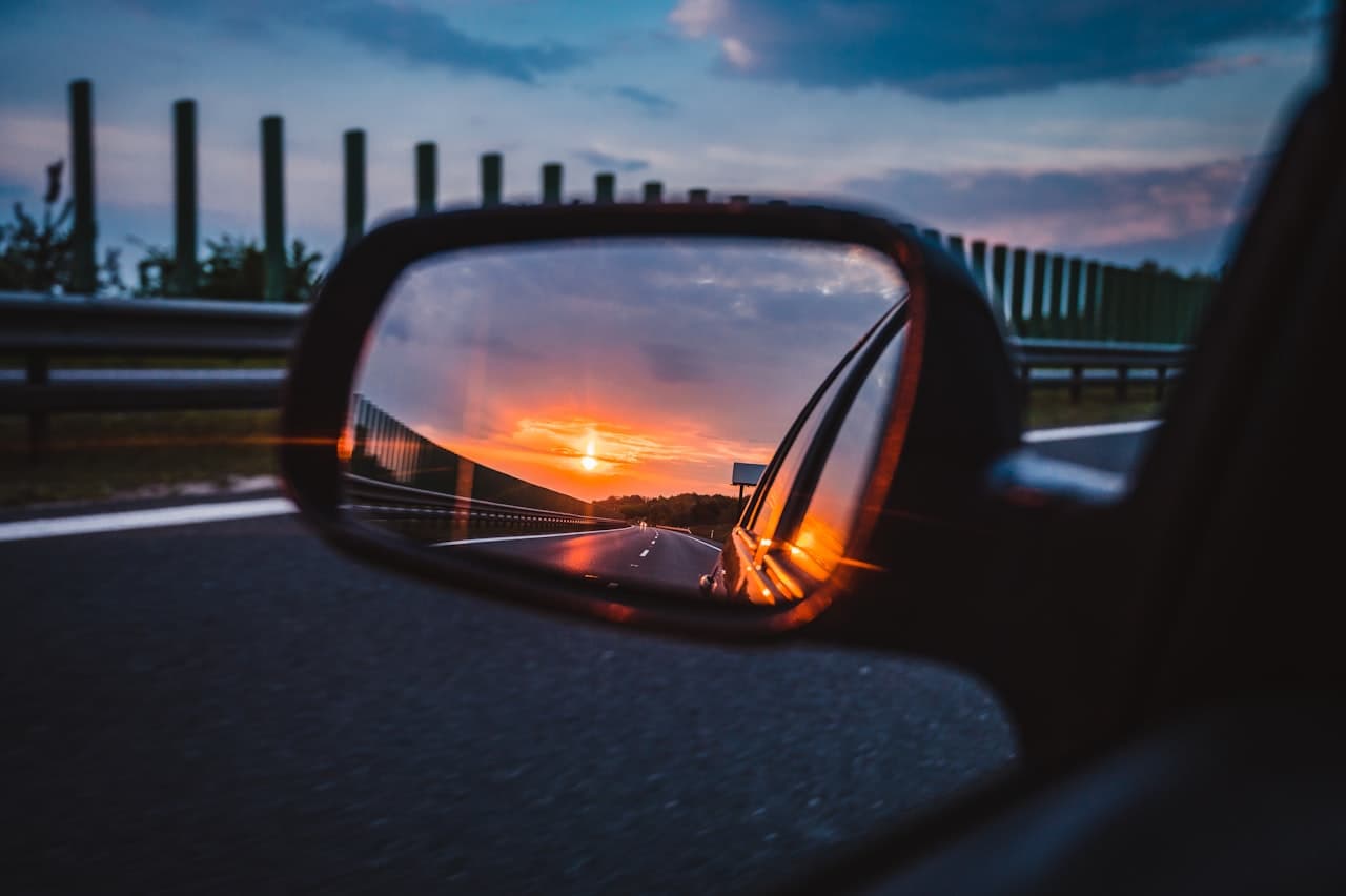 Rétroviseur de voiture reflétant un coucher de soleil