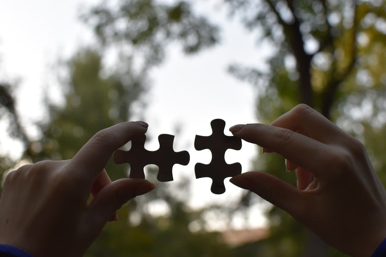 Mains tenant deux pièces de puzzle dans la nature