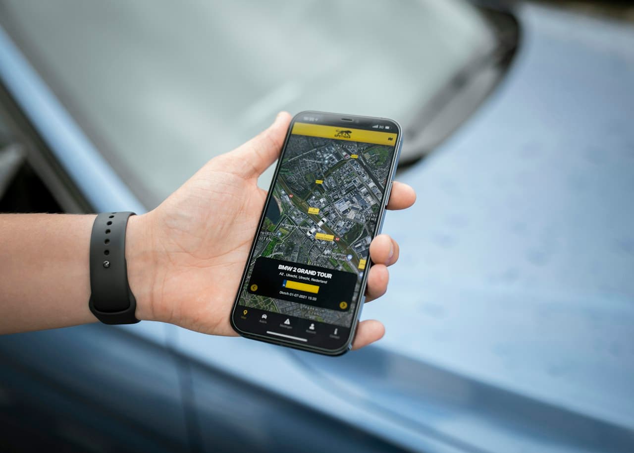 Main tenant un smartphone affichant une application de géolocalisation