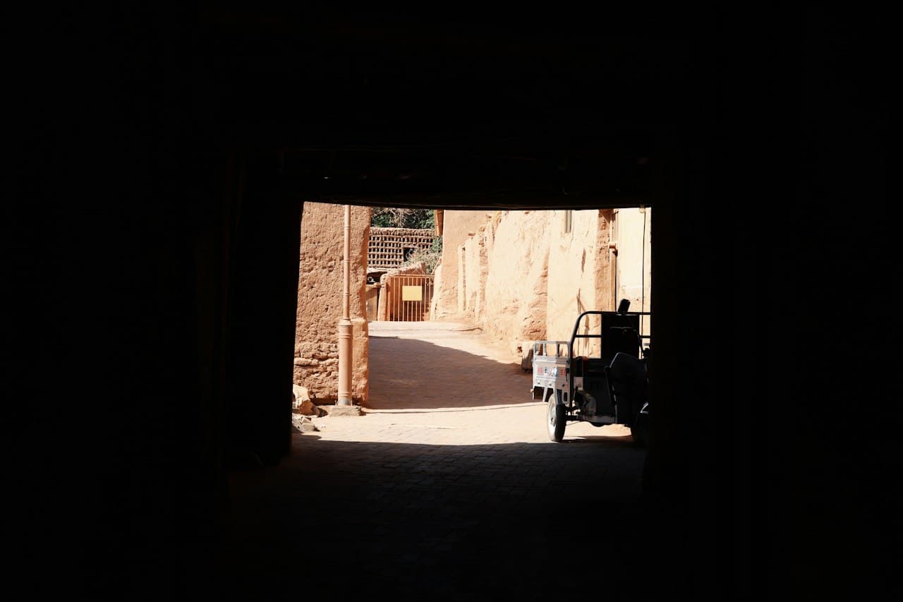 Porte entrouverte donnant sur une ruelle obscure