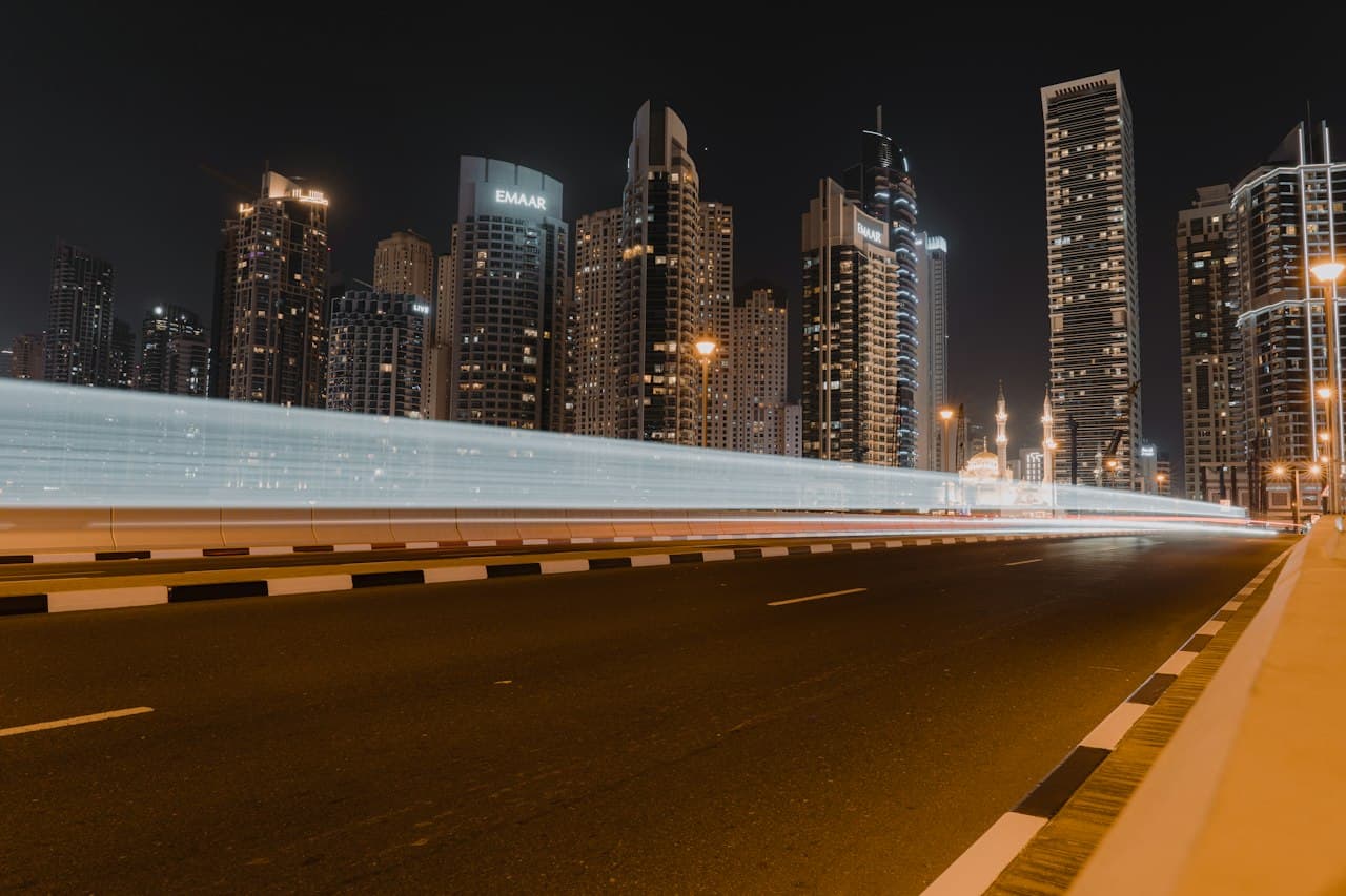 Autoroute vide de nuit avec horizon urbain illuminé