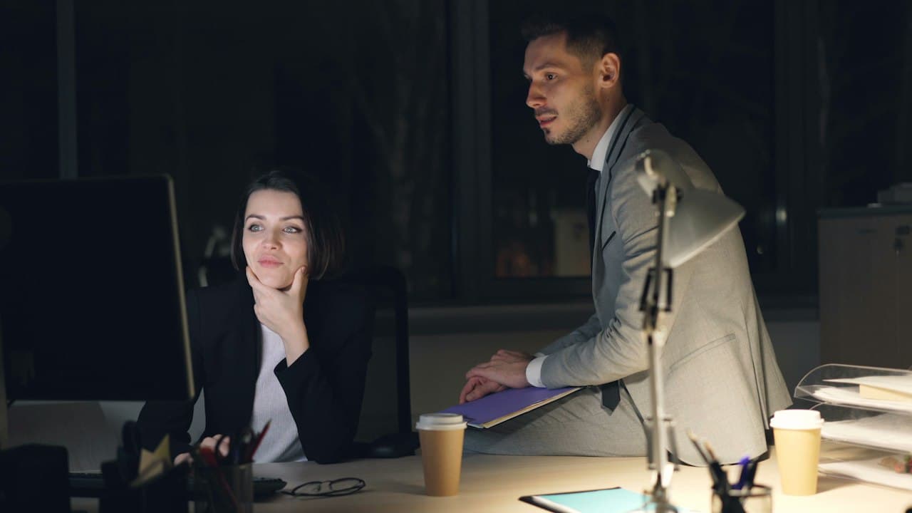 Deux collègues travaillant tard au bureau sur des logiciels