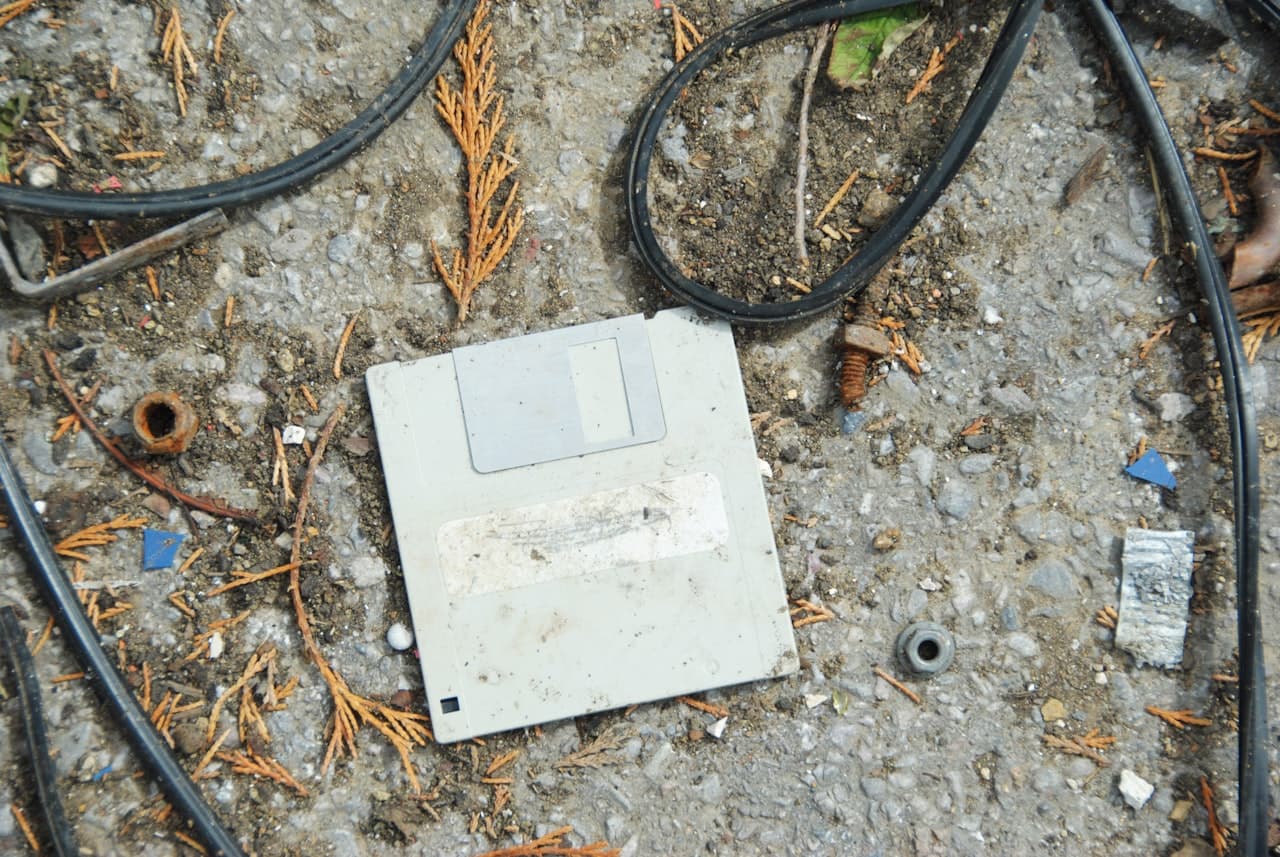 Vieil ordinateur abandonné entouré de câbles enchevêtrés