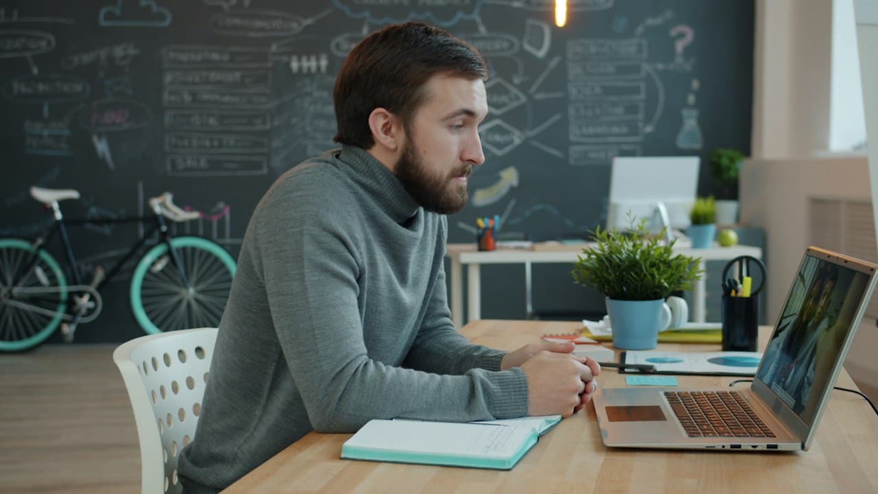 Homme travaillant sur ordinateur portable dans un bureau moderne